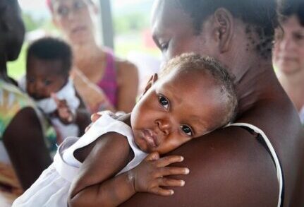 Holistic Haitian Alliance | get involved cta corporate sponsorship snuggling Haitian baby
