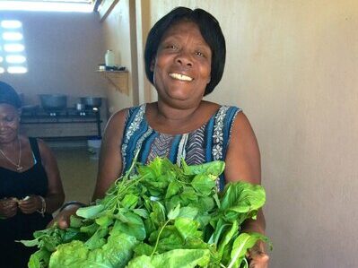 Holistic Haitian Alliance | sustainable agriculture Haitian Woman with Greens