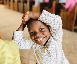 Holistic Haitian Alliance | discipleship 2 smiling Haitian child praising God in church